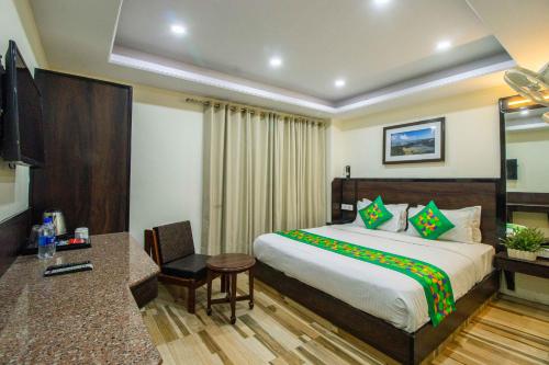 a hotel room with a bed and a desk at Treebo Maharaja, Near Mall Road in Shimla