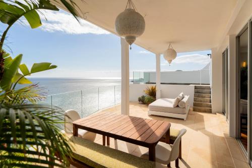 a living room with a table and a view of the ocean at Casa Mar Dream House Old Town Funchal in Funchal