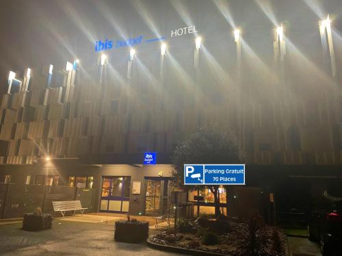 a hotel sign in front of a building at night at Ibis Budget Le Havre Les Docks in Le Havre