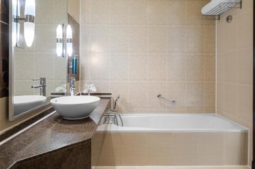 a bathroom with a tub and a sink at DoubleTree by Hilton Sharks Bay Resort in Sharm El Sheikh