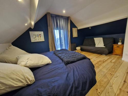 une chambre avec un grand lit et un canapé dans l'établissement La petite champêtre, à Bouconville-Vauclair