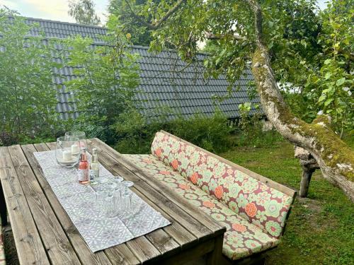 a wooden picnic table with a couch and glasses on it at Blockhütte Engeln-Eifel in Kempenich