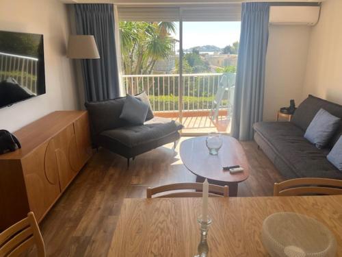 a living room with a couch and a table at Résidence Carlton - Rénovée avec Piscine in Beaulieu-sur-Mer