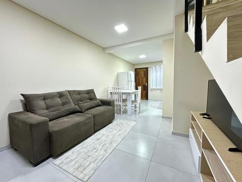 a living room with a couch and a table at Casa moderna com garagem e Wi-Fi perto do Aeroporto in Joinville