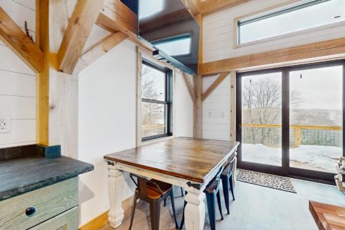 a dining room with a wooden table in a tiny house at Timber Riverhouse in Readsboro