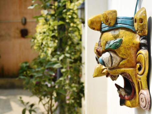 a yellow fire hydrant with a face on it at Shakya House in Pātan