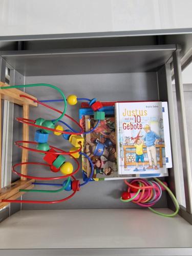 a shelf in a refrigerator with a book and toys at Ferienwohnung - Nachtigall 1 in Bad Hersfeld