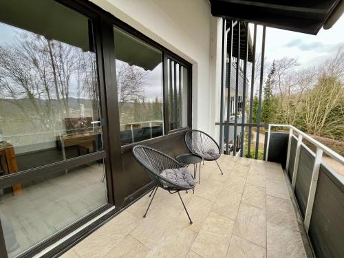 two chairs sitting on a balcony with windows at Harzperle am Ravensberg in Bad Sachsa
