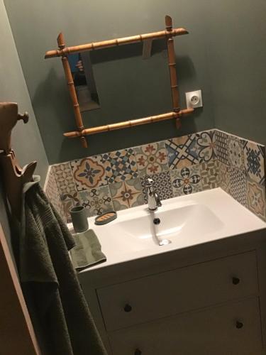 La salle de bains est pourvue d'un lavabo et de carrelage sur le mur. dans l'établissement La maison de Paty, à Paimpol