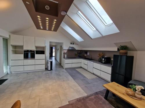 a kitchen with white cabinets and skylights at Ferienwohnung - Nachtigall 1 in Bad Hersfeld