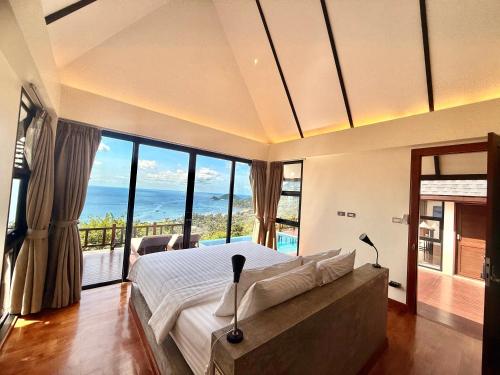 una camera con un grande letto e vista sull'oceano di Taoruna Villa a Ko Tao