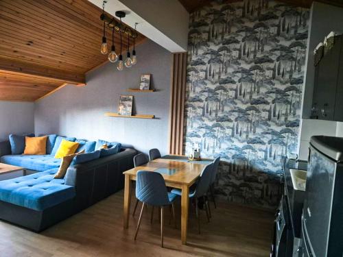 a living room with a blue couch and a table at Nordic Sunset Retreat in Pamporovo