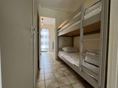Cette chambre comprend 2 lits superposés et un couloir. dans l'établissement Appartement 2 pièces 4 couchages Saint Pierre d'Oléron SPO000-613, à Saint-Pierre-dʼOléron