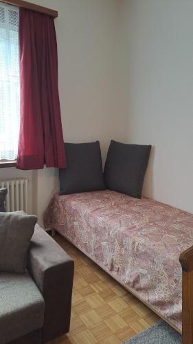 a bedroom with a bed and a couch and a window at Casa Di Vacanza Cevio in Cevio