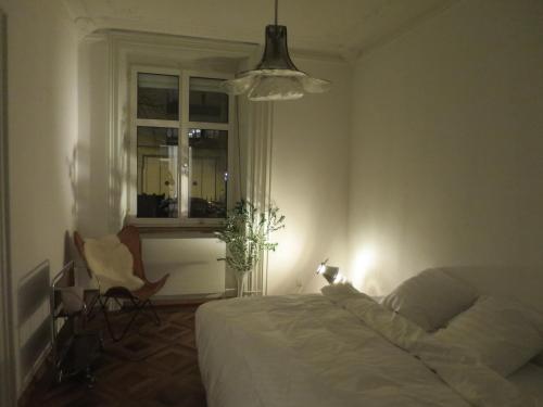 a bedroom with a bed and a chair and a window at inHere-outThere in Basel