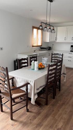 una cucina con un tavolo e sedie con un tavolo e un tavolo di Maison Lumière a Lagorce