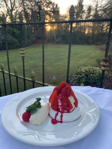 a plate of food with strawberries on a table at Brook Hall Hotel in Childer Thornton