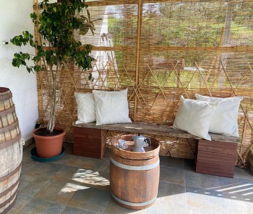 a wooden bench with pillows and a barrel at Da Nonno Francesco in Teulada