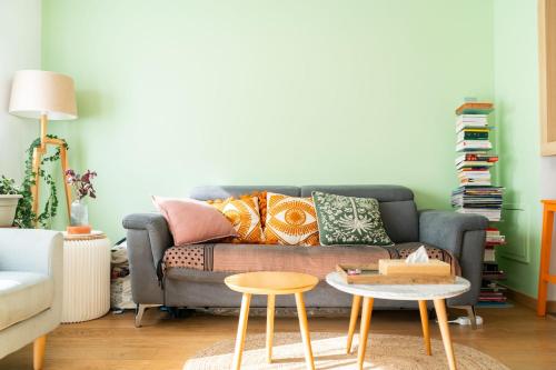 - un salon avec un canapé et deux tabourets dans l'établissement T2 apartment with garden near Paris, à Montreuil