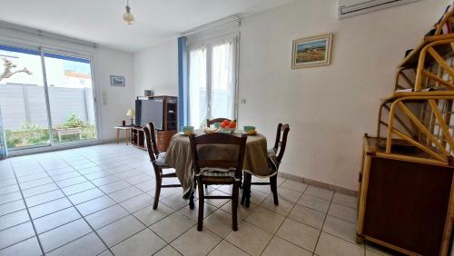 une salle à manger avec une table et des chaises dans une pièce dans l'établissement Villa LA DIVA Agréable villa familiale climatisée proche plage - 3 chambres - jardin et terrasse, à Saint Cyprien Plage