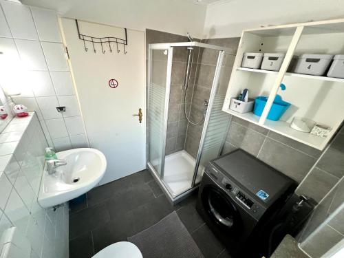 a bathroom with a shower sink and a washing machine at Monteur Unterkunft 6 Betten in Karben