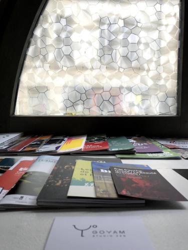 une pile de livres assis sur une table devant une fenêtre dans l'établissement Arènes 1 à deux pas du centre historique, à Besançon