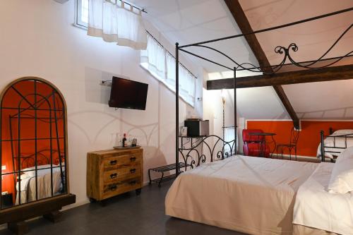 une chambre avec un lit et une télévision au mur dans l'établissement Palazzo della Loggia B&B, à Naples