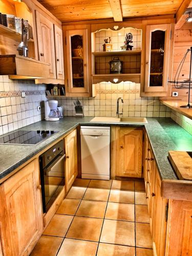- une cuisine avec des placards en bois et un lave-vaisselle blanc dans l'établissement Chez Fernande, à Notre-Dame-de-Bellecombe