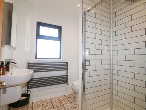 une salle de bains avec douche, toilettes et lavabo dans l'établissement Holm Oaks Cottage, à Godalming
