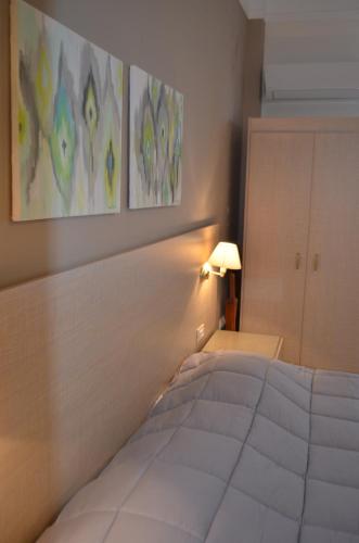 a bedroom with a white bed and a lamp at Archontissa in Ermoupoli