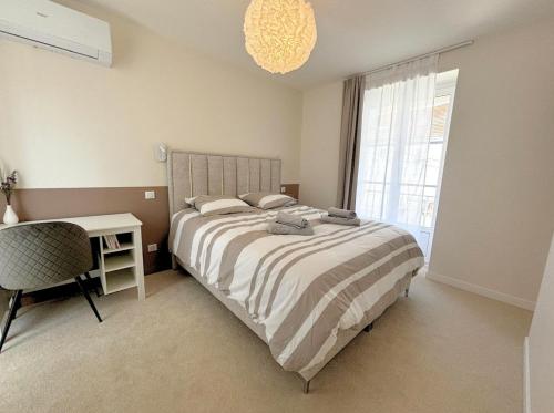 une chambre avec un lit, un bureau et une fenêtre dans l'établissement Les Sapins, T2 hyper centre avec climatisation, à Lons-le-Saunier