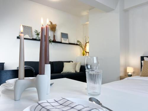 Cheap, Near Beach & Easy Parking - by Solstad في كافالا: غرفة مع طاولة مع شمعتين وأريكة