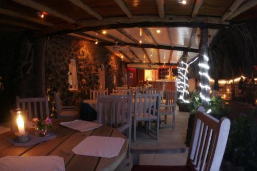 un comedor con mesas blancas, sillas y velas en Hotel Angermeyer Waterfront Inn, en Puerto Ayora