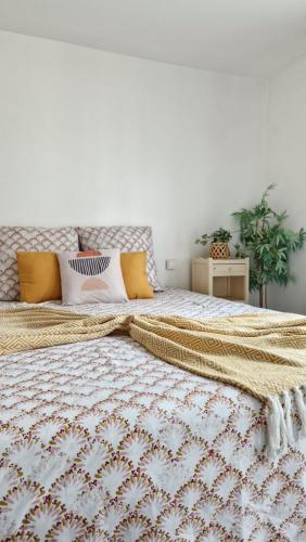 une chambre avec un grand lit avec des oreillers jaunes dans l'établissement Le Cosy Hyper Centre d'Orléans, à Orléans