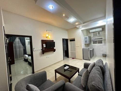 哈伊勒Hotel alras line Suites的带沙发、桌子和电视的客厅