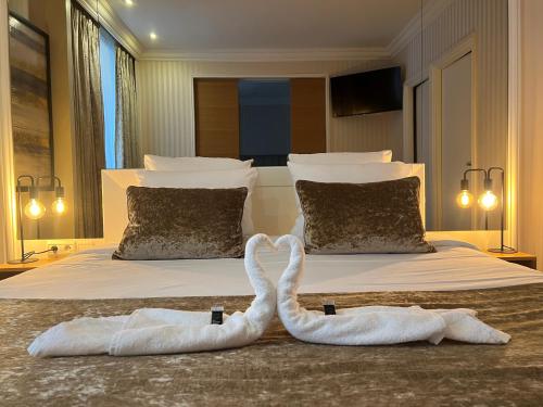 two swans towels on a bed in a bedroom at Maison LUTETIA R in Strasbourg