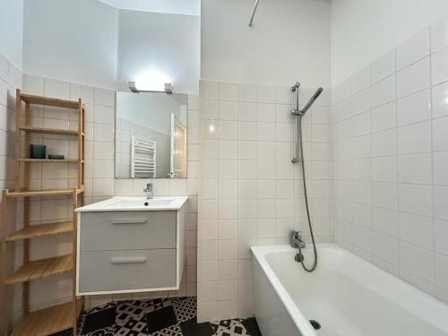 une salle de bain avec une baignoire et un lavabo et une baignoire dans l'établissement Saint Thierry spacieux 6 personnes proche centre, à Reims