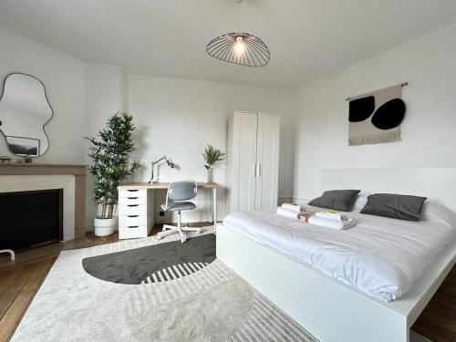 une chambre blanche avec un lit blanc et un bureau dans l'établissement Saint Thierry spacieux 6 personnes proche centre, à Reims