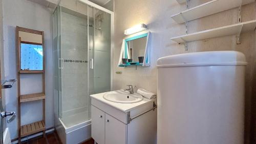 une salle de bain blanche avec un lavabo et une douche dans l'établissement Le Grand Large, au Crotoy