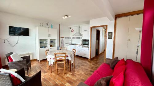 un salon avec un canapé rouge et une table dans l'établissement Le Grand Large, au Crotoy