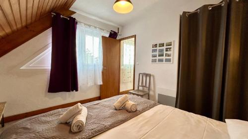 une chambre avec un lit avec deux serviettes dessus dans l'établissement Le Grand Large, au Crotoy