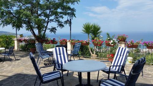 a patio with chairs and tables and flowers at Villa Malandrino Guest House in Agropoli