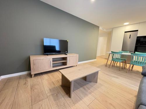 a living room with a tv and a couch and a table at REUSIA Apartaments in Reus