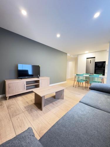 a living room with a couch and a tv and a table at REUSIA Apartaments in Reus