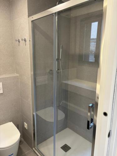 a glass shower in a bathroom with a toilet at REUSIA Apartaments in Reus