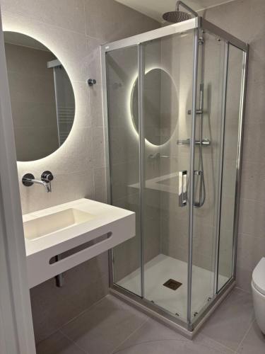 a bathroom with a glass shower and a sink at REUSIA Apartaments in Reus