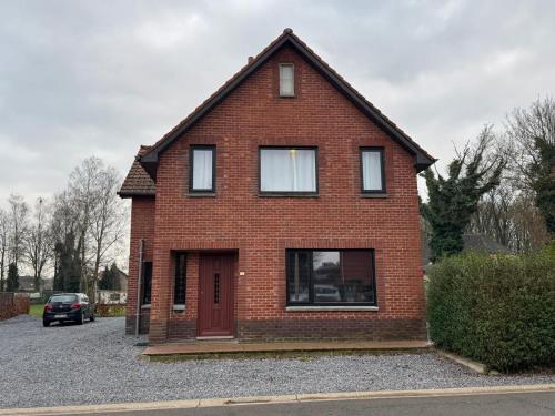 a red brick house with a red door at Vakantiewoning Gruitrode in Oudsbergen 