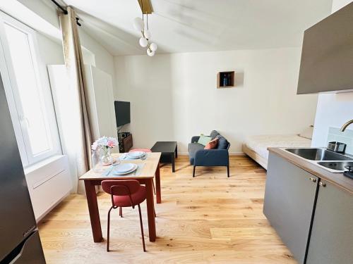 une cuisine et un salon avec une table et un canapé dans l'établissement Appartement Cosy - Château Gombert, à Marseille
