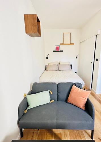 - un canapé bleu dans une chambre avec un lit dans l'établissement Appartement Cosy - Château Gombert, à Marseille