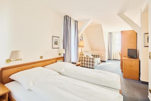 a hotel room with two beds and a television at Hotel & Restaurant zum Ritter in Attendorn